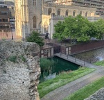 Old ruins and a man made lake with skyscrapers in the background